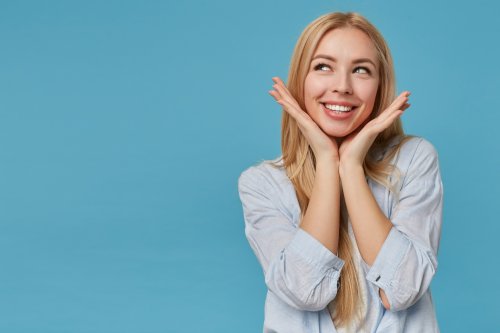 attractive-young-blonde-woman-with-long-hair-leaning-her-head-raised-palms-standing-casual-clothes-looking-aside-with-charming-smile.jpg