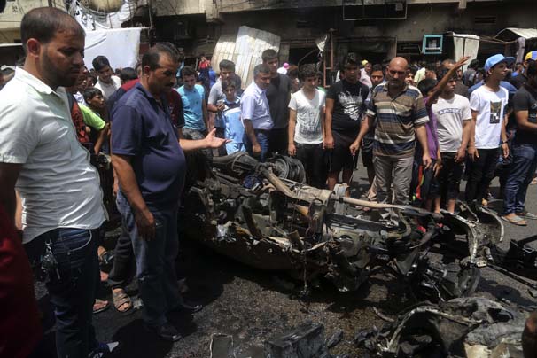Citizens inspect the scene after a car bomb explosion at a crowded outdoor market in the Iraqi capital's eastern district of Sadr City, Iraq, Wednesday, May 11, 2016. An explosives-laden car bomb ripped through a commercial area in a predominantly Shiite neighborhood of Baghdad on Wednesday, killing and wounding dozens of civilians, a police official said. (AP Photo/ Khalid Mohammed)